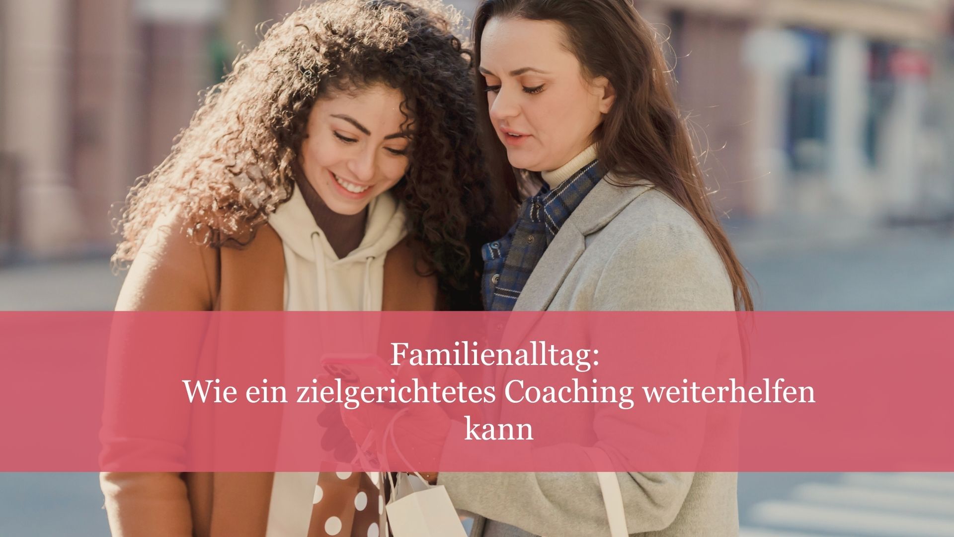 Beitragsbild: Zwei Frauen blicken unterhaltend auf ein Handy.